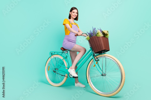 Fototapeta Naklejka Na Ścianę i Meble -  Full body photo of charming young happy woman ride bike smile summer isolated on pastel teal color background