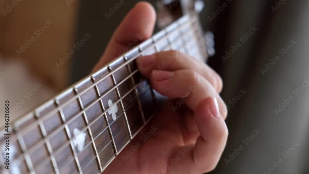 Musical instrument. Musician plays and picks chords. Man plays acoustic guitar, clamps the strings Close-up. Daylight. Man's hands playing on a guitar neck, soft focus. Rock, Blues, Jazz, Pop music. Musical instrument. Musician plays and picks chords. Man plays acoustic guitar, clamps the strings Close-up. Daylight. Man's hands playing on a guitar neck, soft focus. Rock, Blues, Jazz, Pop music.