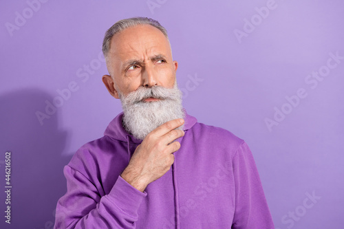 Portrait of attractive bewildered grey-haired man overthinking copy space isolated over purple violet color background