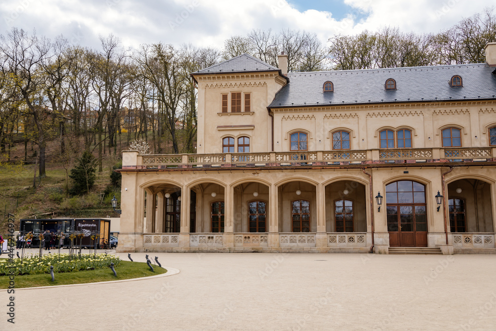 Prague, Czech Republic, 25 April 2021:  Slechtas or Slechtova restaurant with green lawn, Lower summer house baroque palace at Stromovka park at spring day, balcony and arcades of the first floor