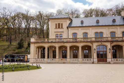 Prague, Czech Republic, 25 April 2021:  Slechtas or Slechtova restaurant with green lawn, Lower summer house baroque palace at Stromovka park at spring day, balcony and arcades of the first floor