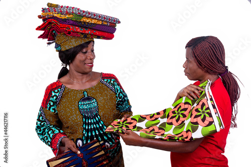 beautiful woman showing different traditional loincloths to a client while smiling.