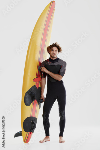 Young european curly surfer stand with surfboard