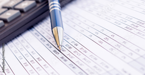 financial balance sheet with calculator and pen