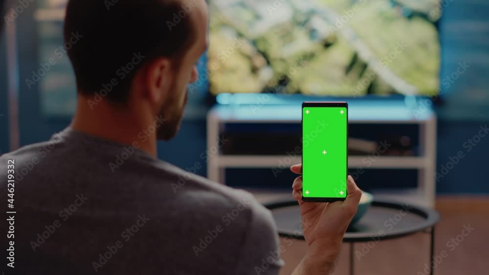 Person with modern smartphone looking at green screen vertical ...
