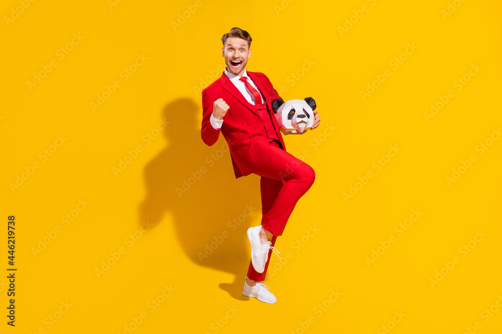 Photo of astonished winner guy hold panda head celebrate victory wear red suit tie isolated on yellow color background