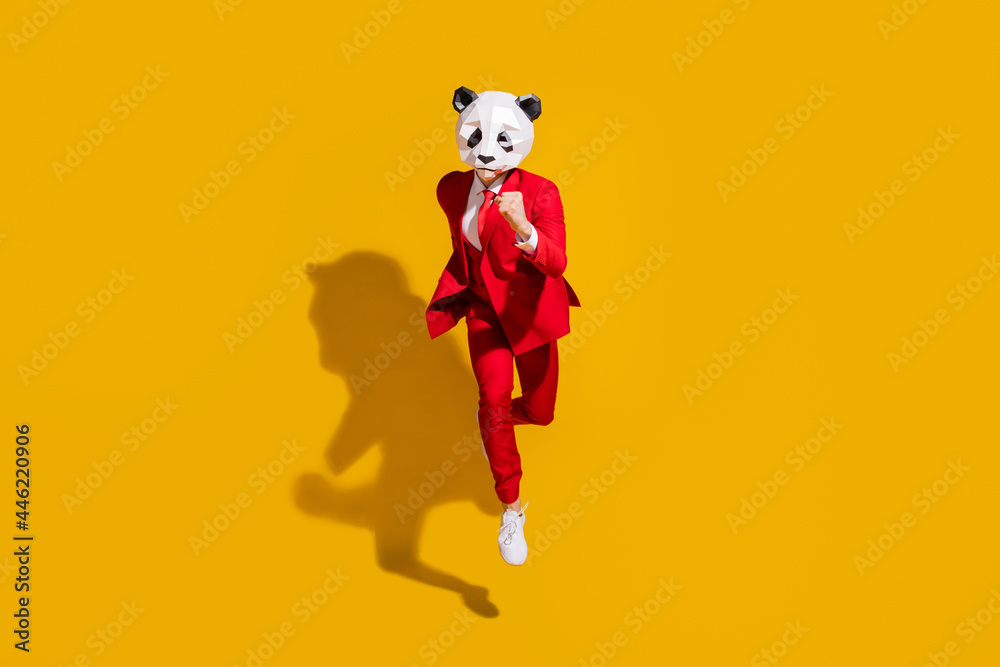 Photo of incognito panda guy jump run fast wear mask red tuxedo footwear isolated on yellow color background Photo of incognito panda guy jump run fast wear mask red tuxedo footwear isolated on yellow color background