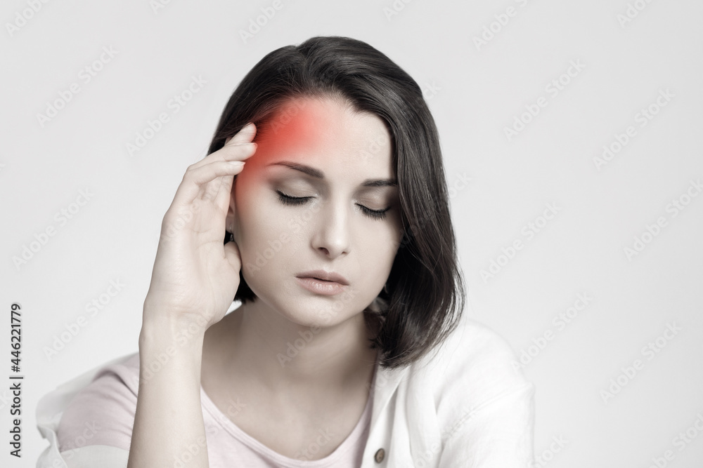 Tired sad brunette woman touches her head, migraine, pain area of red color. Headache concept. Tired sad brunette woman touches her head, migraine, pain area of red color. Headache concept.