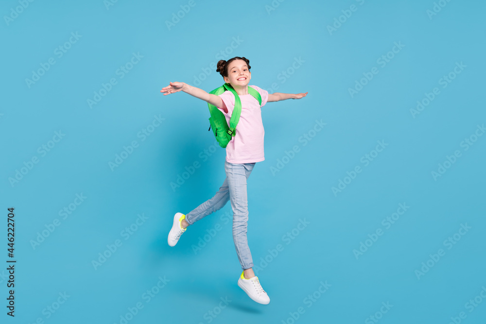 Photo of cute adorable schoolgirl dressed pink t-shirt rucksack jumping high walking smiling isolated blue color background Photo of cute adorable schoolgirl dressed pink t-shirt rucksack jumping high walking smiling isolated blue color background