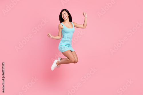Full length profile photo of hooray young lady jump wear blue dress sneakers isolated on pink color background