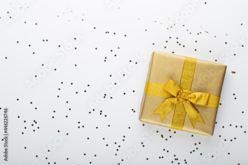 Gift or present box and stars confetti on color table top view. Flat lay composition for birthday, mother day or wedding. © gitusik