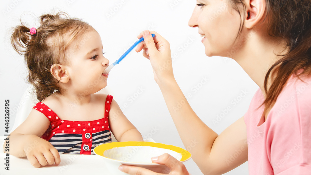 Mother feeding her little baby with healthy food Mother feeding her little baby with healthy food