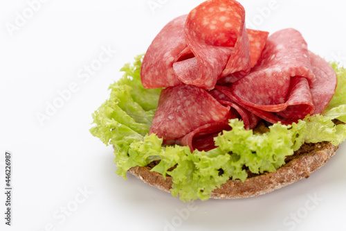 Sandwich with salami sausage on white background.