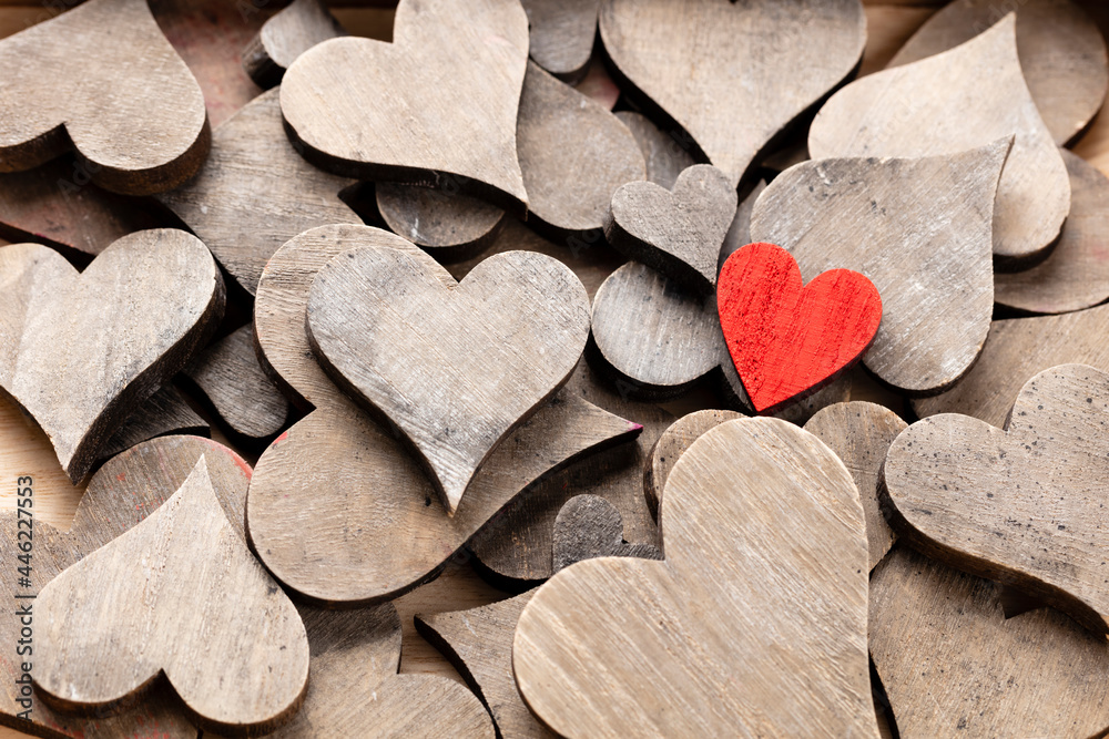 Obraz premium Wooden hearts, one red heart on the heart background..
