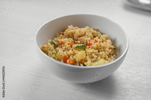 Bulgur with vegetables in the bowl on the white wooden table. Concept of Healthy Food. Healthy diet concept. Super Food. Vegetarian.