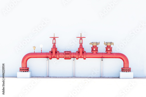 Fotografía Pipe or row of red color fire fighting or tap water sprinkler supply pipeline system on white background