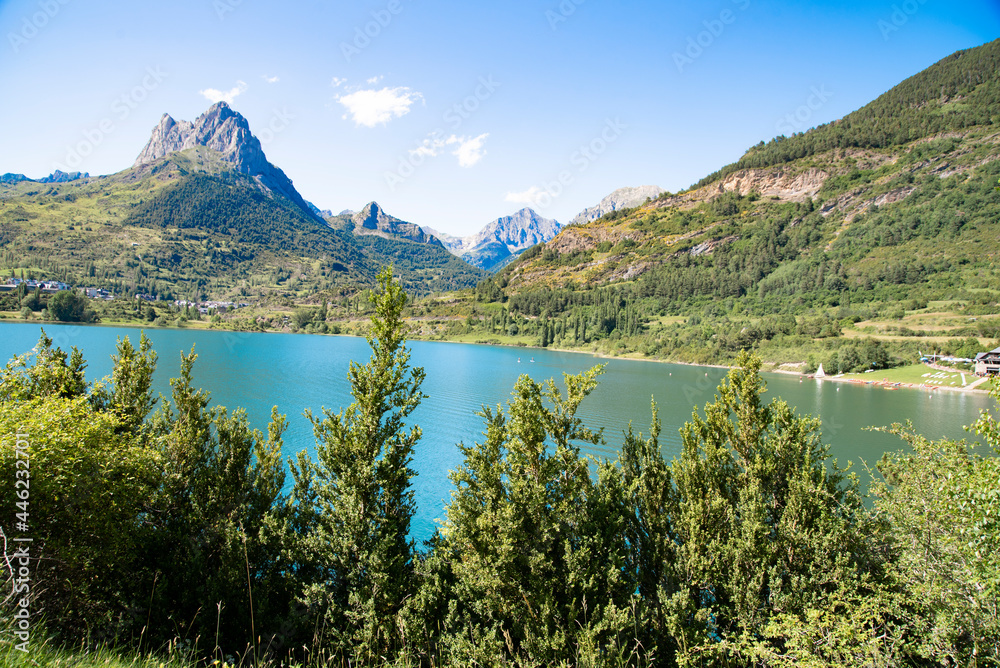 The Lanuza reservoir, located at the head of the Tena valley at the foot of Sallente de Gállego and formed by the waters of the Gallego river. Above Sallent, the impressive Peña Foratata stands out.