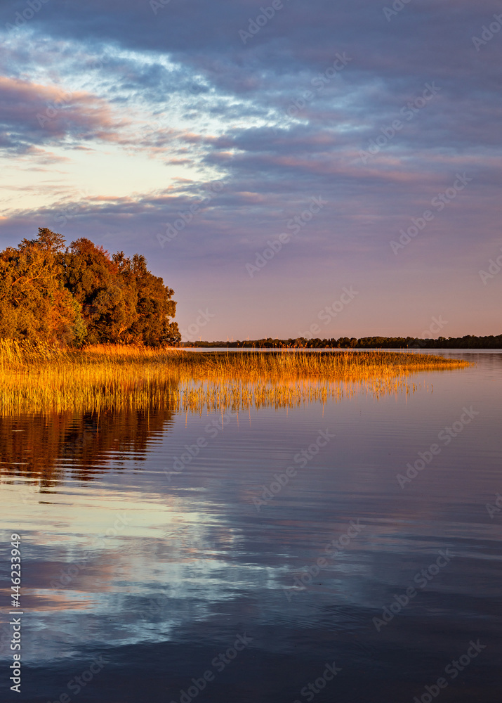 Panoramic summer sunset view of Jezioro Selmet Wielki lake landscape with reeds and wooded shoreline in Sedki village in Masuria region of Poland - obrazy, fototapety, plakaty 