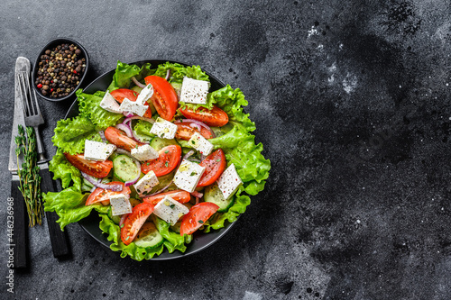 Bowl of ready-to-eat Greek salad. Black background. Top view. Copy space