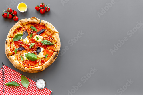 Homemade pizza margarita with tomatoes and basil on the table