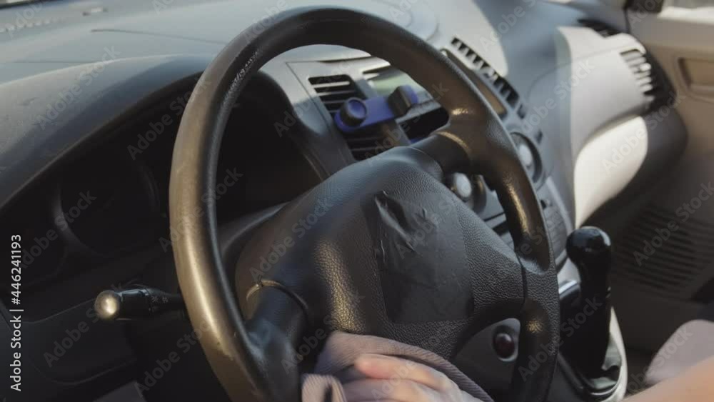 Handheld close up shot of unrecognizable man in disposable gloves spraying antiseptic on car wheel and wiping it with cloth Handheld close up shot of unrecognizable man in disposable gloves spraying antiseptic on car wheel and wiping it with cloth
