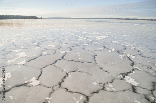 Frozen Lake Usma with cracked ice. Sunny winter day without snow. 
