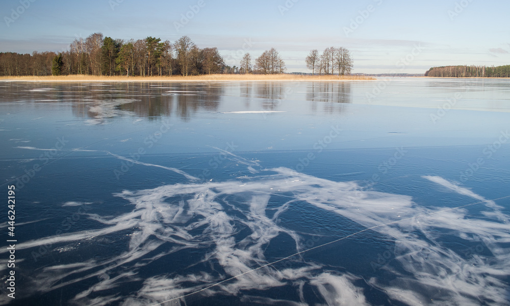 Frozen Lake Usma with cracked ice. Sunny winter day without snow. 