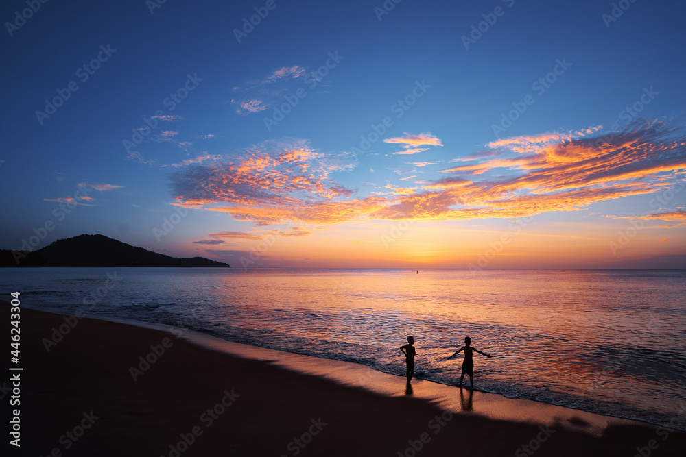 Kids playing on the beach. Sunset on the sea shore.