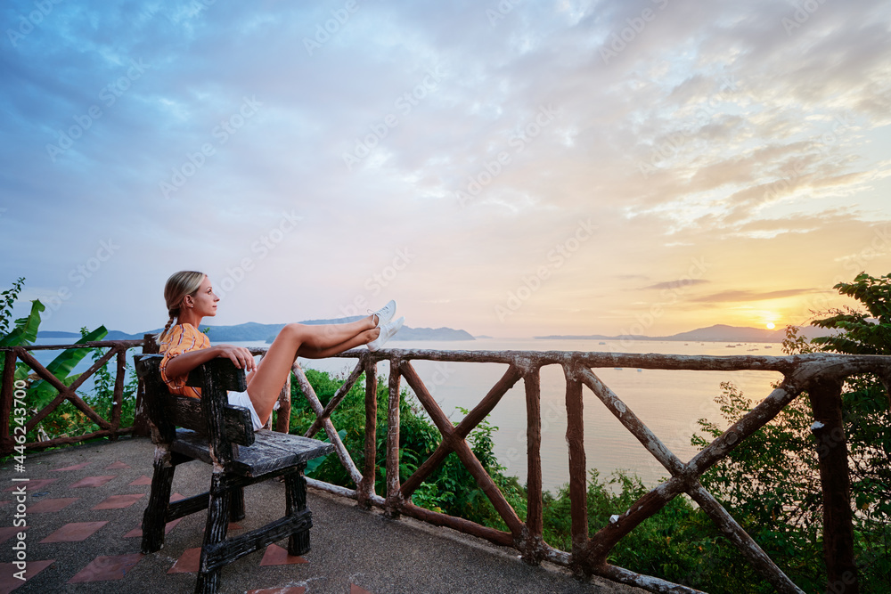 Traveling by Thailand. Young woman enjoying wonderful sunset on Phuket island view point.