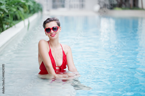 Enjoying vacation. Beautiful young woman in swimming pool. © luengo_ua