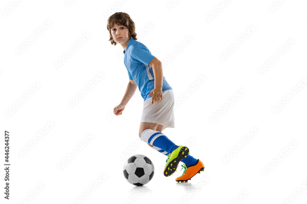 Portrait of preschool boy, football soccer player in action, motion training isolated on white studio background. Concept of sport, game, hobby