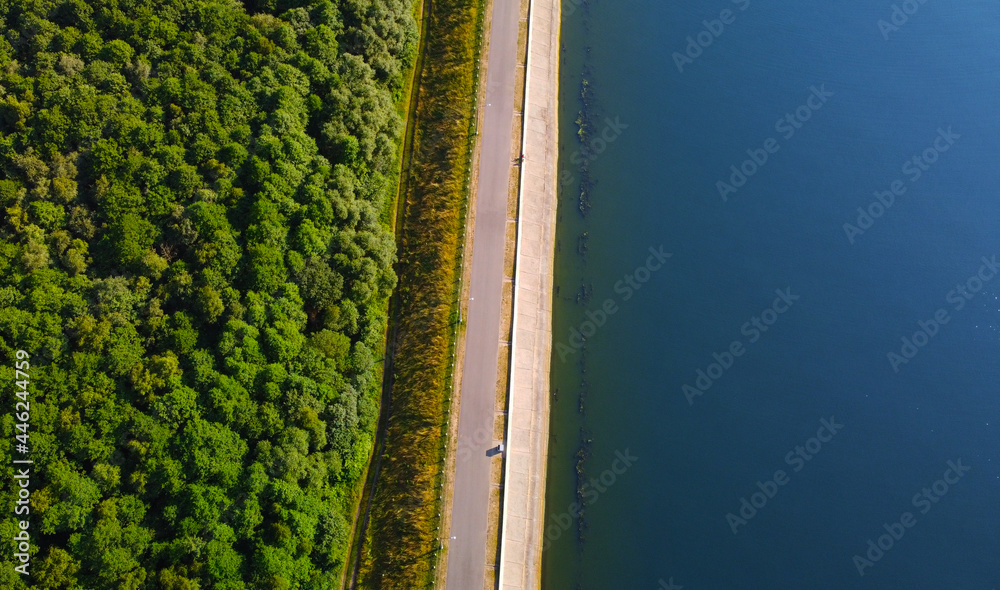 Aerial view of flat, straight lake shoreline with road