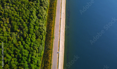 Aerial view of flat, straight lake shoreline with road