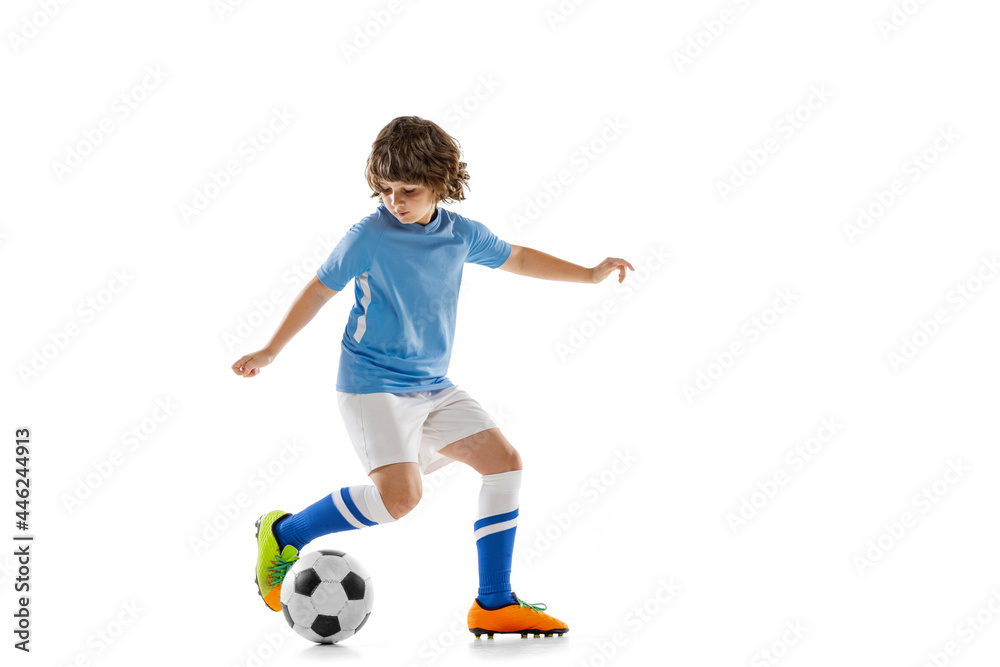 Portrait of preschool boy, football soccer player in action, motion training isolated on white studio background. Concept of sport, game, hobby