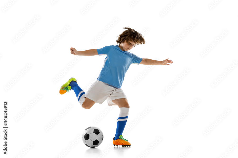 Portrait of preschool boy, football soccer player in action, motion training isolated on white studio background. Concept of sport, game, hobby