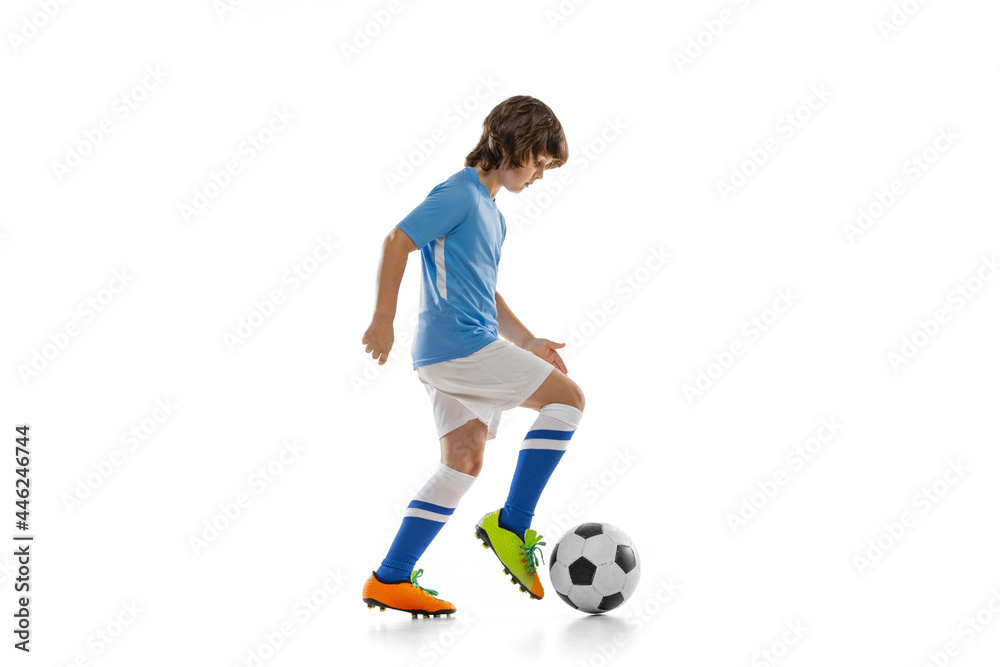 One preschool boy, football soccer player in action, motion training isolated on white studio background. Concept of sport, game, hobby