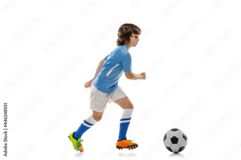 One preschool boy, football soccer player in action, motion training isolated on white studio background. Concept of sport, game, hobby