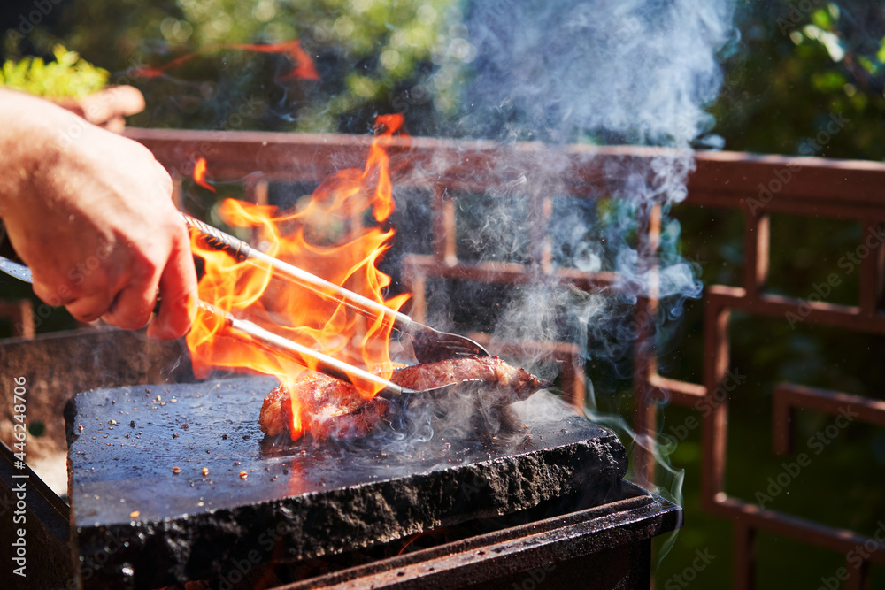 Barbecue beef burger steak. Cutlet meat placed on grill stone with fire. Barbecue beef burger steak. Cutlet meat placed on grill stone with fire.