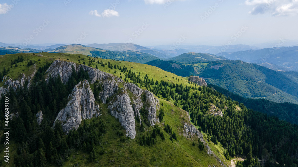 View at a peak and valley in Kopaonik mountains in summer, Serbia. Summer mountains green forest and rock peaks. Travel and vacation concept.