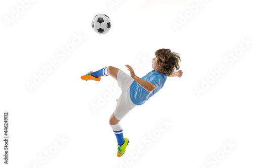 Young male football soccer player, boy training with football ball isolated on white studio background. Concept of sport, game, hobby