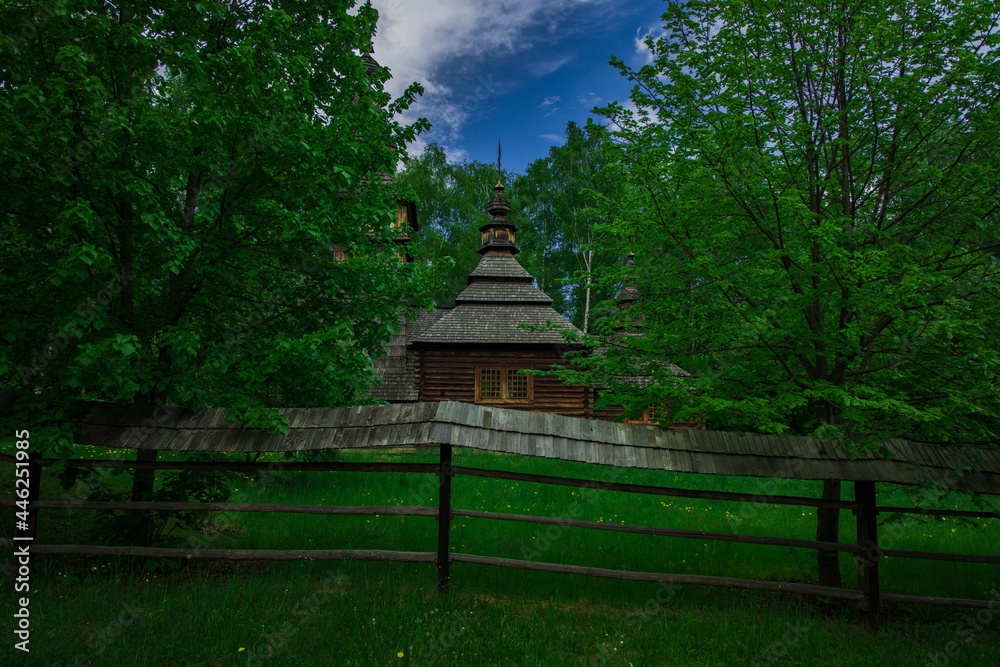 ancient wooden church in country side forest edge picturesque natural place surrounded by palisade and green foliage in summer season day time ancient wooden church in country side forest edge picturesque natural place surrounded by palisade and green foliage in summer season day time