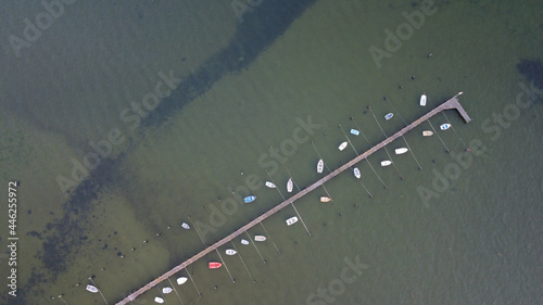 Aerial view of small boats moored on a pier in Poole harbour from directly above