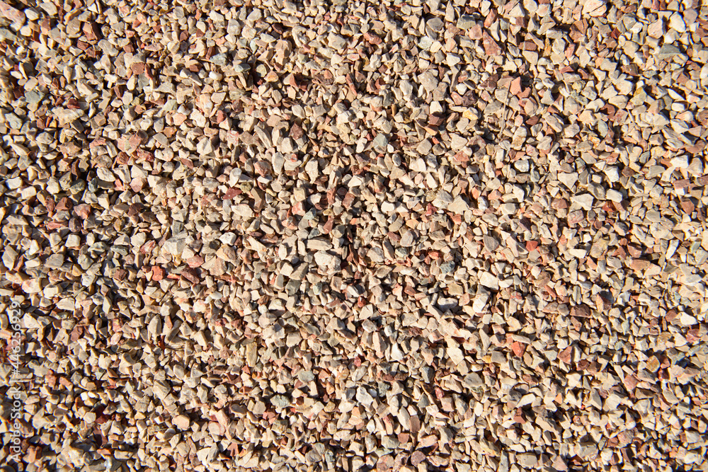 The surface is covered with small stones of white, pink, gray colors. The surface is covered with small stones of white, pink, gray colors.