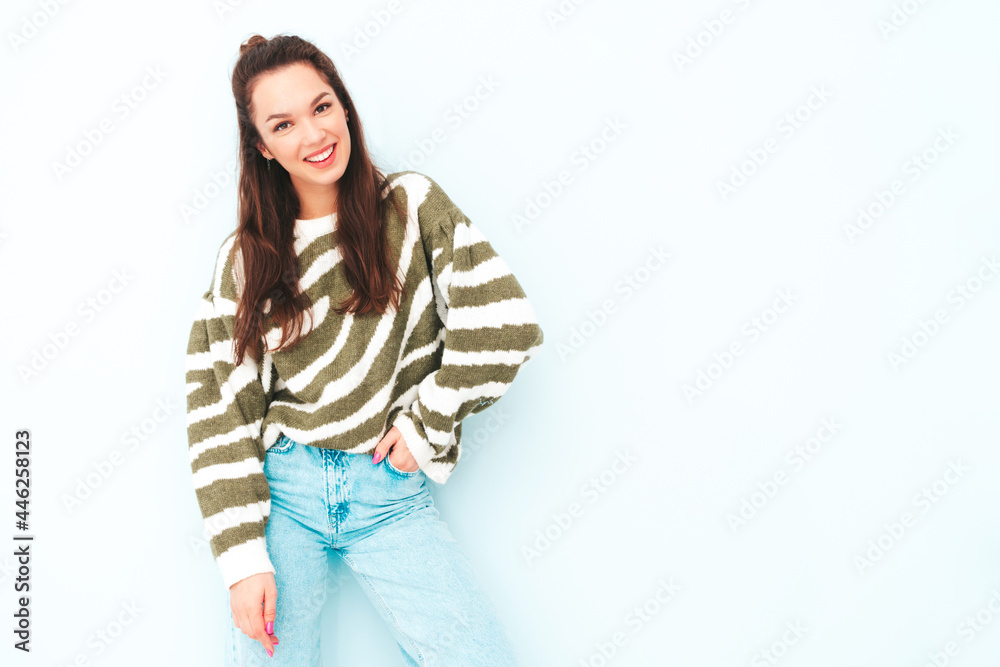 Young beautiful smiling female in trendy summer hipster clothes. Sexy carefree woman posing near light blue wall in studio. Positive model having fun indoors. Cheerful and happy Young beautiful smiling female in trendy summer hipster clothes. Sexy carefree woman posing near light blue wall in studio. Positive model having fun indoors. Cheerful and happy