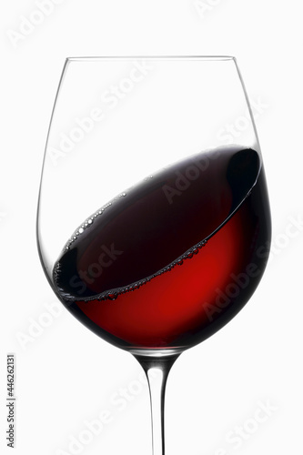 Red wine swirling around a wine glass, with bubbles