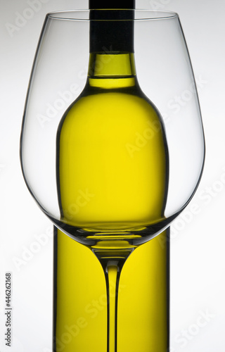 Wine glass with white wine bottle in background