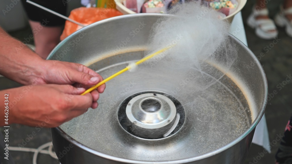 The process of making cotton candy on the street.