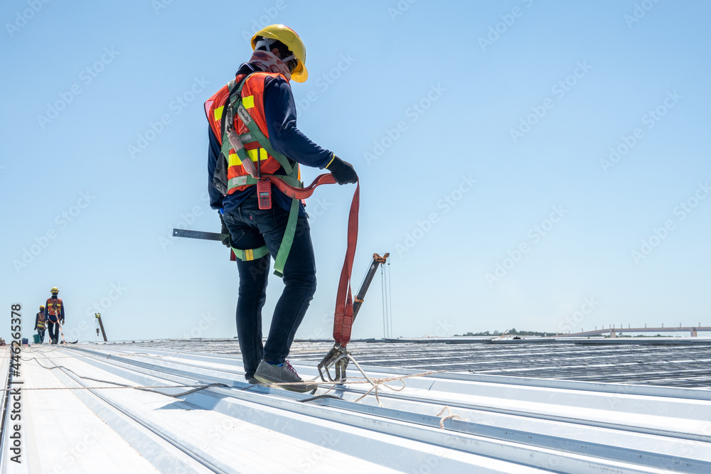Construction worker wearing PPE woking at roof  - obrazy, fototapety, plakaty 