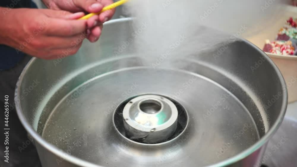 The process of making cotton candy on the street. The process of making cotton candy on the street.