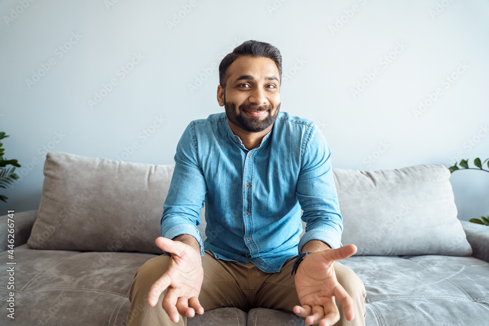 Handsome young indian man talking to camera feeling clueless confused gesturing